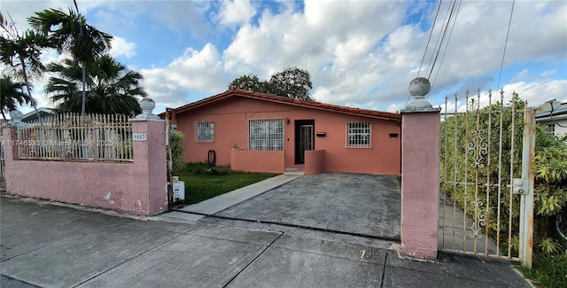 view of side of property featuring a fenced front yard, a gate, and stucco siding