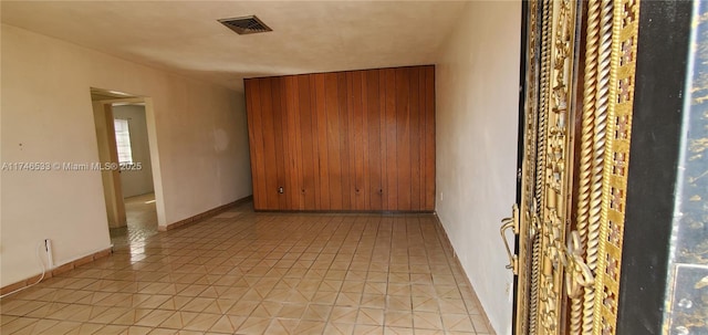 spare room featuring light tile patterned floors, baseboards, and visible vents