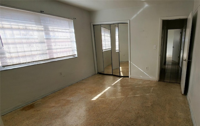 unfurnished bedroom featuring a closet and speckled floor