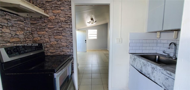 kitchen with stainless steel electric stove, decorative backsplash, light tile patterned flooring, a sink, and under cabinet range hood