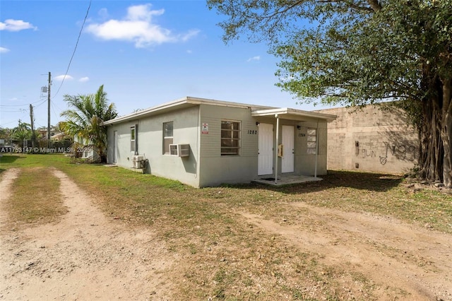 view of front of home with cooling unit and dirt driveway