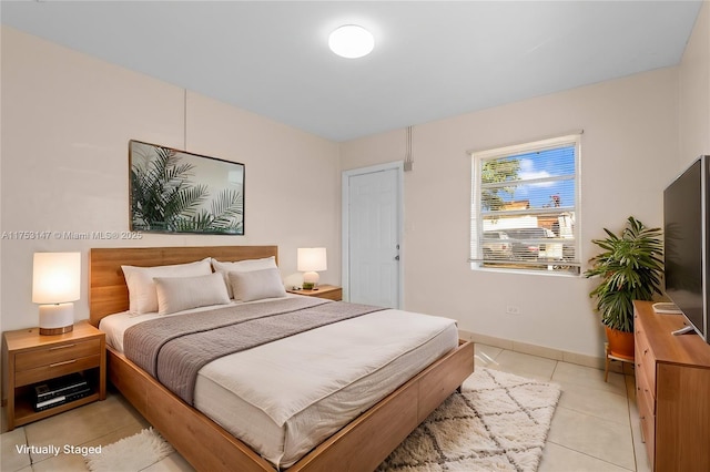 bedroom featuring light tile patterned floors and baseboards