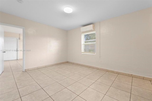 unfurnished room featuring an AC wall unit, baseboards, and light tile patterned floors