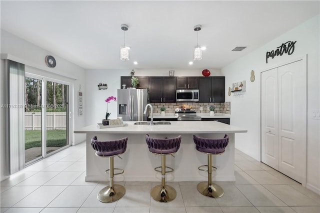 kitchen featuring light countertops, visible vents, backsplash, appliances with stainless steel finishes, and a sink