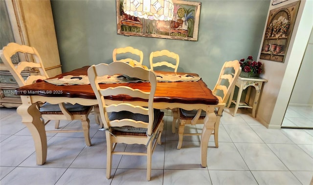 dining area with baseboards and tile patterned floors