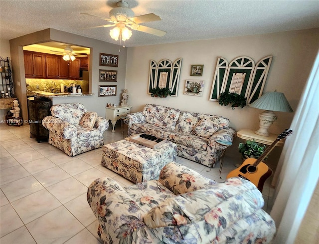 living room with light tile patterned floors, a ceiling fan, and a textured ceiling