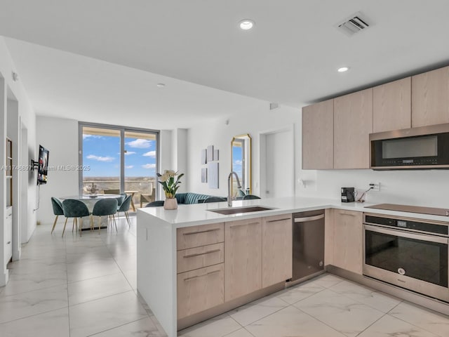 2000 Metropica Way Unit 1507, Sunrise, FL 33323 - kitchen featuring expansive windows, light brown cabinets, appliances with stainless steel finishes, and a sink