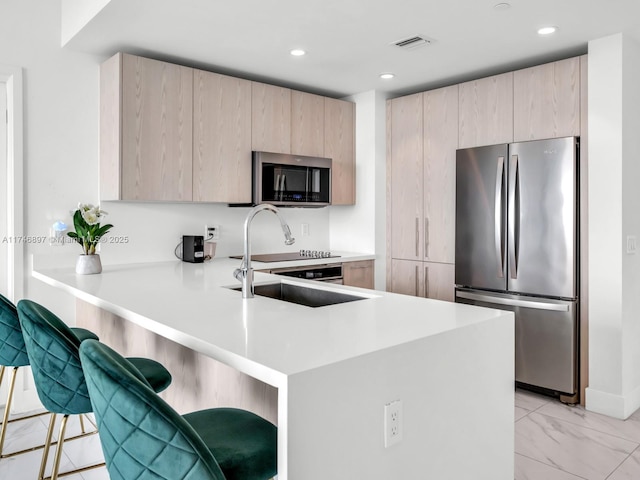 2000 Metropica Way Unit 1507, Sunrise, FL 33323 - kitchen with a peninsula, a sink, visible vents, appliances with stainless steel finishes, and light brown cabinetry