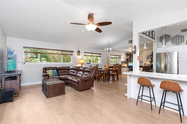 living area with light wood-style floors, visible vents, vaulted ceiling, and ceiling fan with notable chandelier