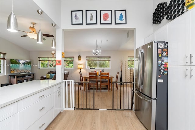 kitchen featuring light countertops, freestanding refrigerator, white cabinets, and light wood finished floors