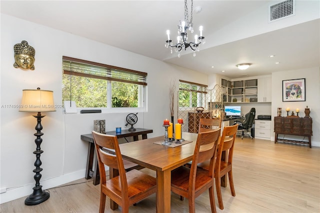 dining area featuring visible vents, light wood-type flooring, a chandelier, built in desk, and recessed lighting