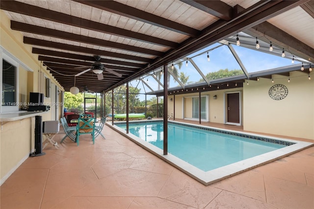 pool with a ceiling fan, glass enclosure, and a patio area