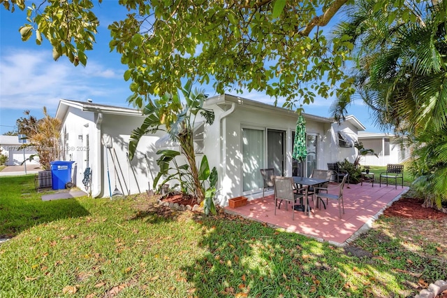 6820 NW 17th Ct, Margate, FL 33063 - back of property with stucco siding, a patio, and a lawn