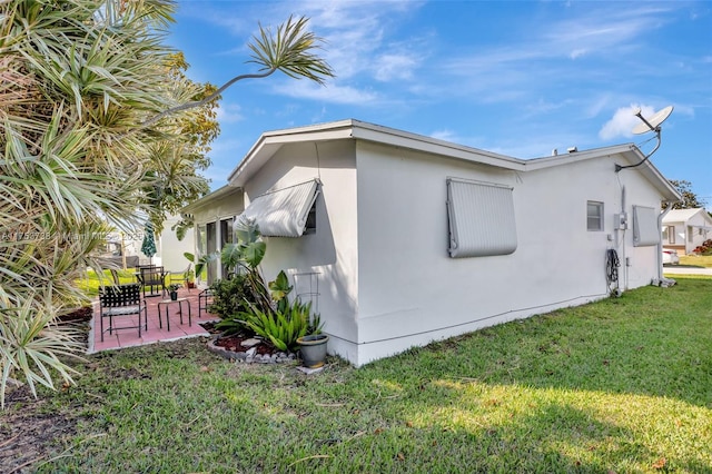 6820 NW 17th Ct, Margate, FL 33063 - view of side of property featuring stucco siding, a lawn, and a patio area