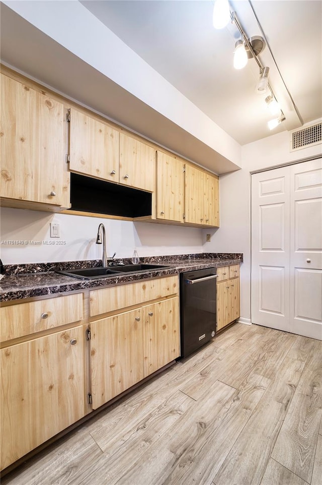 kitchen featuring light brown cabinets, a sink, visible vents, and dishwashing machine