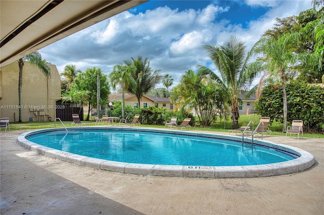 community pool with fence and a patio