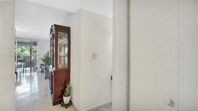 hall with light tile patterned flooring and baseboards