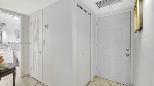 hallway featuring visible vents and light tile patterned floors