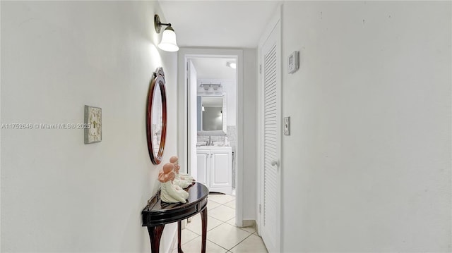 hall with a sink and light tile patterned flooring