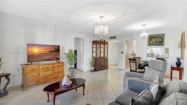 living area featuring visible vents, a chandelier, baseboards, and light tile patterned flooring