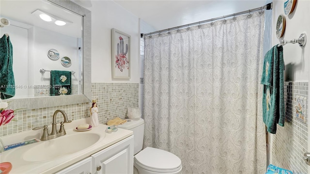 bathroom featuring wainscoting, toilet, a shower with shower curtain, vanity, and tile walls