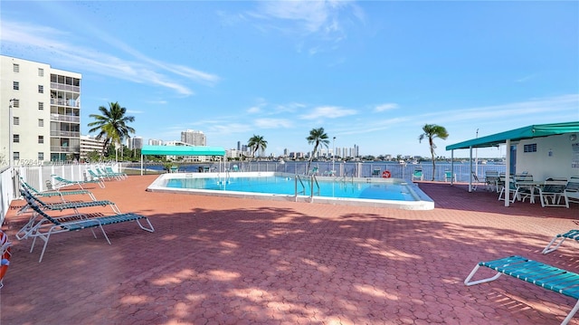 pool with a patio area and fence