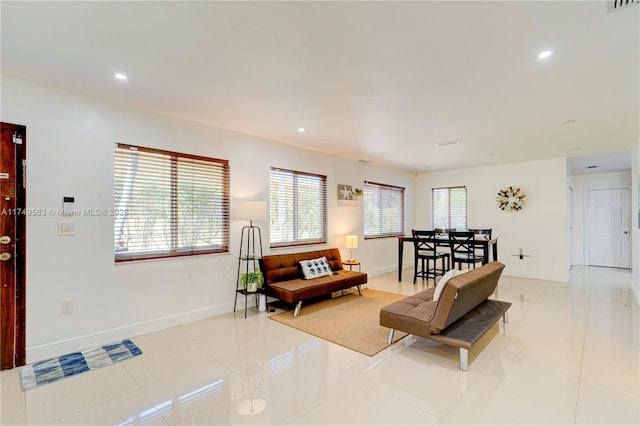 living area featuring light tile patterned floors, baseboards, and recessed lighting