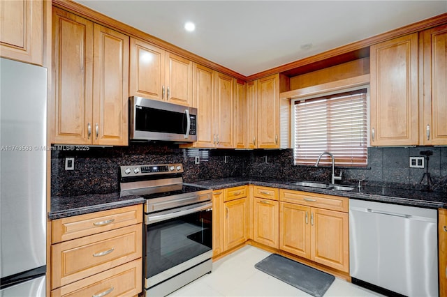 kitchen featuring appliances with stainless steel finishes, dark stone counters, a sink, and backsplash