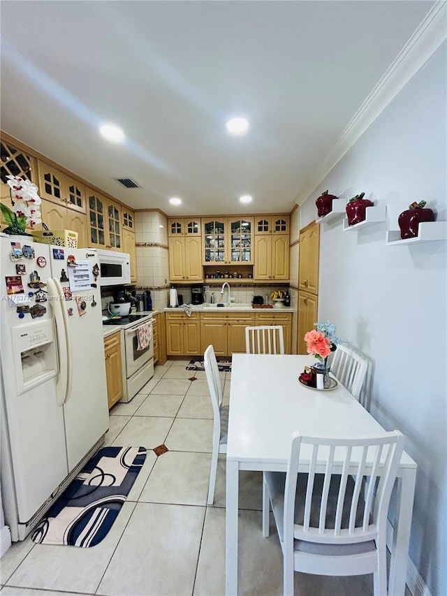 kitchen with white appliances, a sink, visible vents, tasteful backsplash, and glass insert cabinets