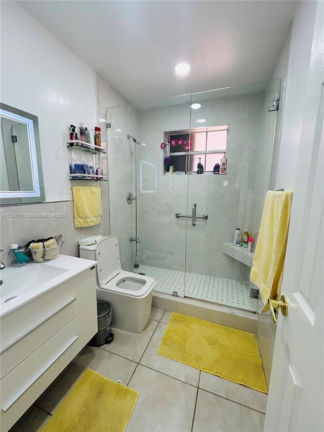 bathroom featuring toilet, tile walls, vanity, a shower stall, and tile patterned floors