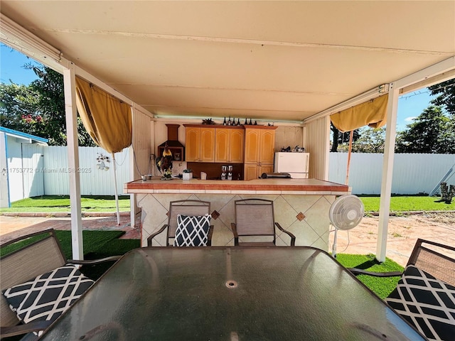 view of patio / terrace featuring fence, outdoor dry bar, and outdoor dining area