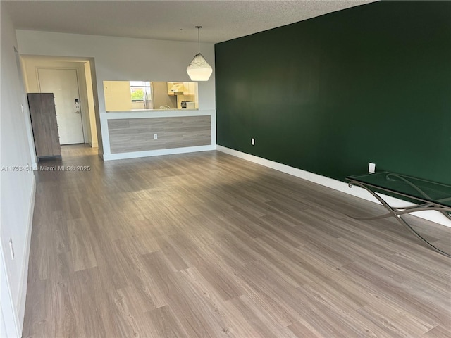 unfurnished room featuring baseboards and wood finished floors