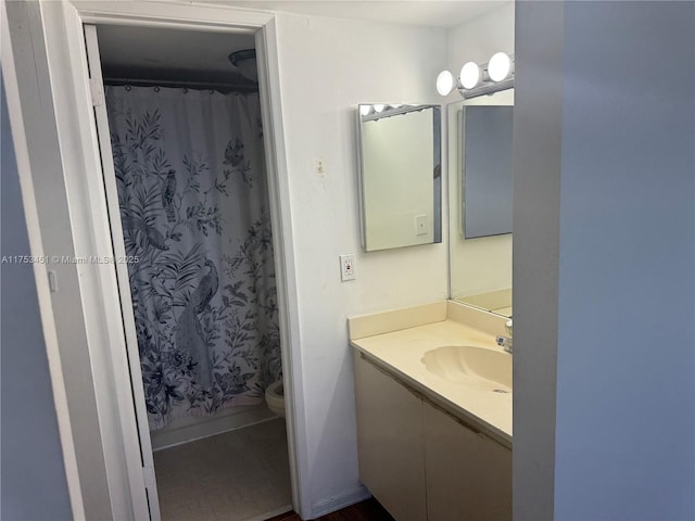 bathroom featuring curtained shower, vanity, and toilet