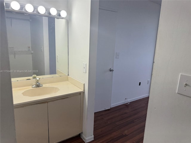 bathroom featuring wood finished floors, vanity, and baseboards