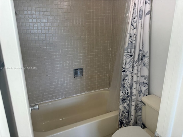 bathroom featuring shower / bath combination with curtain and toilet