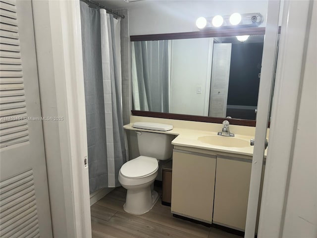 full bath with toilet, wood finished floors, vanity, and a shower with curtain