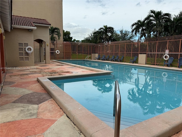 community pool featuring a patio area and fence