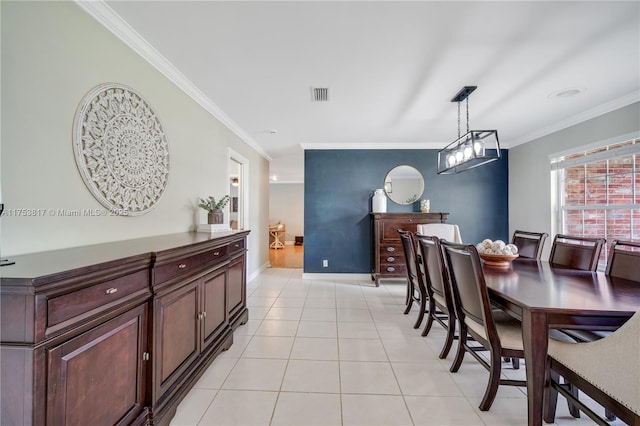 dining room featuring ornamental molding, light tile patterned flooring, visible vents, and baseboards