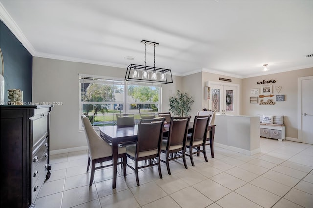 dining area featuring crown molding, baseboards, and light tile patterned floors