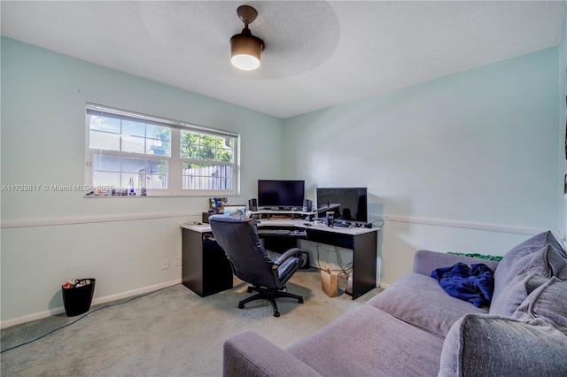 office area with a textured ceiling, baseboards, and light colored carpet