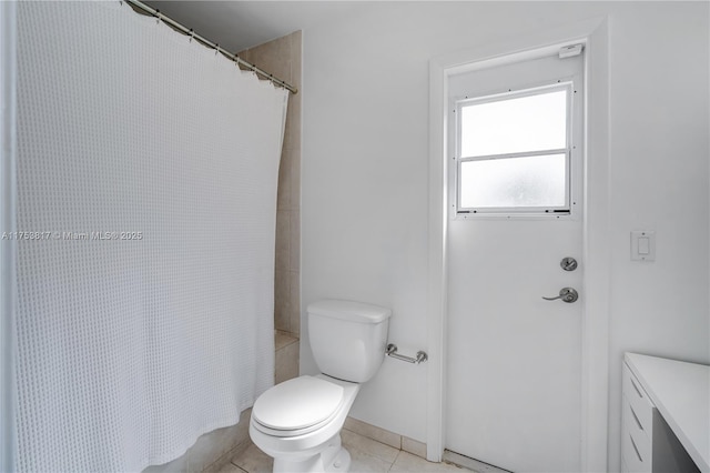 bathroom with tile patterned flooring, a shower with curtain, and toilet