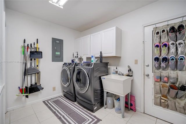 clothes washing area with cabinet space, light tile patterned floors, electric panel, baseboards, and washer and dryer