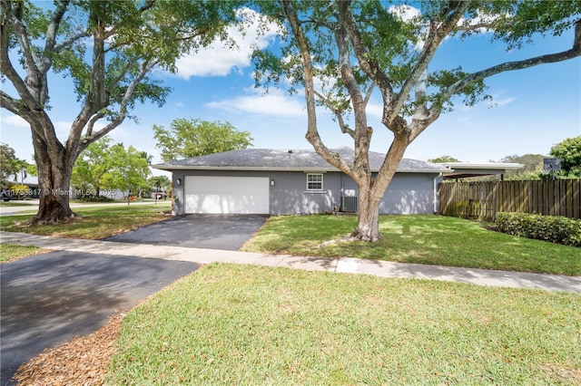 single story home with an attached garage, cooling unit, fence, driveway, and a front yard