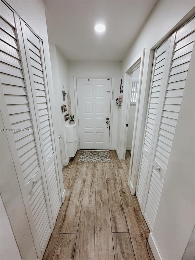 entryway with light wood-style floors, baseboards, and washer / dryer