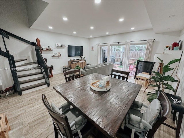 dining area with recessed lighting, baseboards, light wood finished floors, and stairs