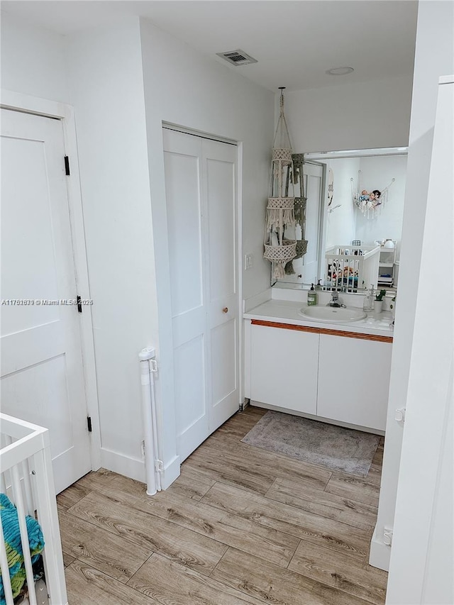 bathroom featuring visible vents, wood finished floors, and vanity