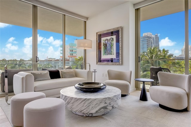 living area featuring light carpet, a view of city, and a wall of windows