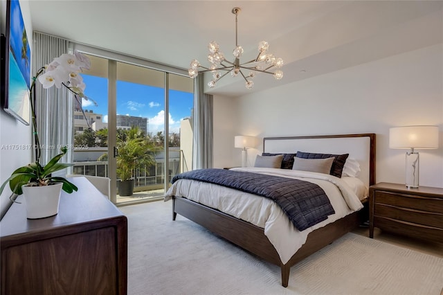 bedroom featuring an inviting chandelier, access to exterior, and a wall of windows