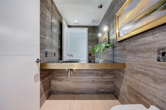 bathroom with visible vents, a tile shower, tile walls, and toilet