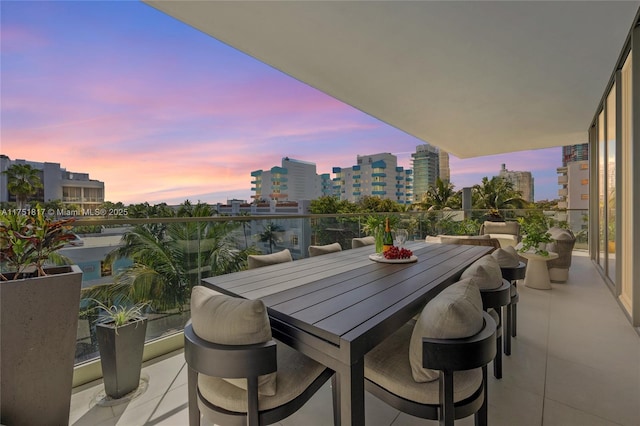 balcony at dusk featuring a city view